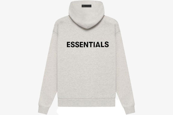 Essentials Core Collection Pullover Hoodie in light gray with black "ESSENTIALS" print on the back.